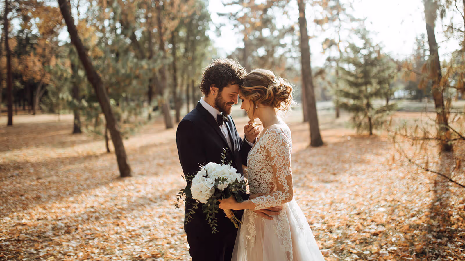 Bride and groom having intimate moment with sun setting in the background