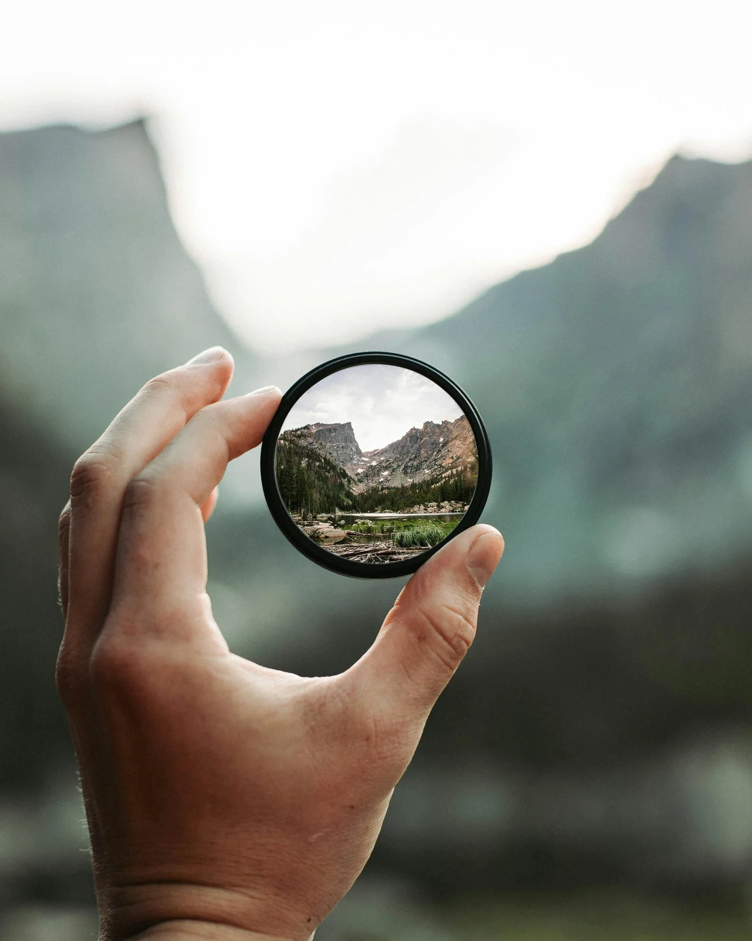 a hand holding a camera lens