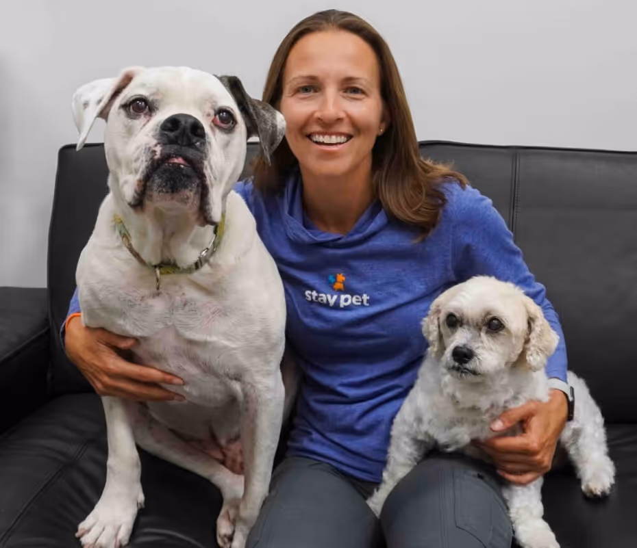 woman sitting on a couch with 2 dogs