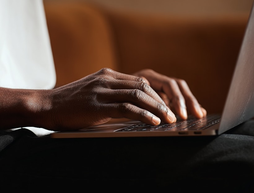 A close up of a person typing on a laptop.