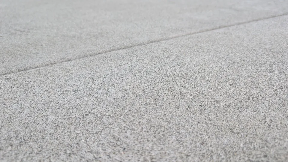 Close-up of a textured concrete surface and a joint line.