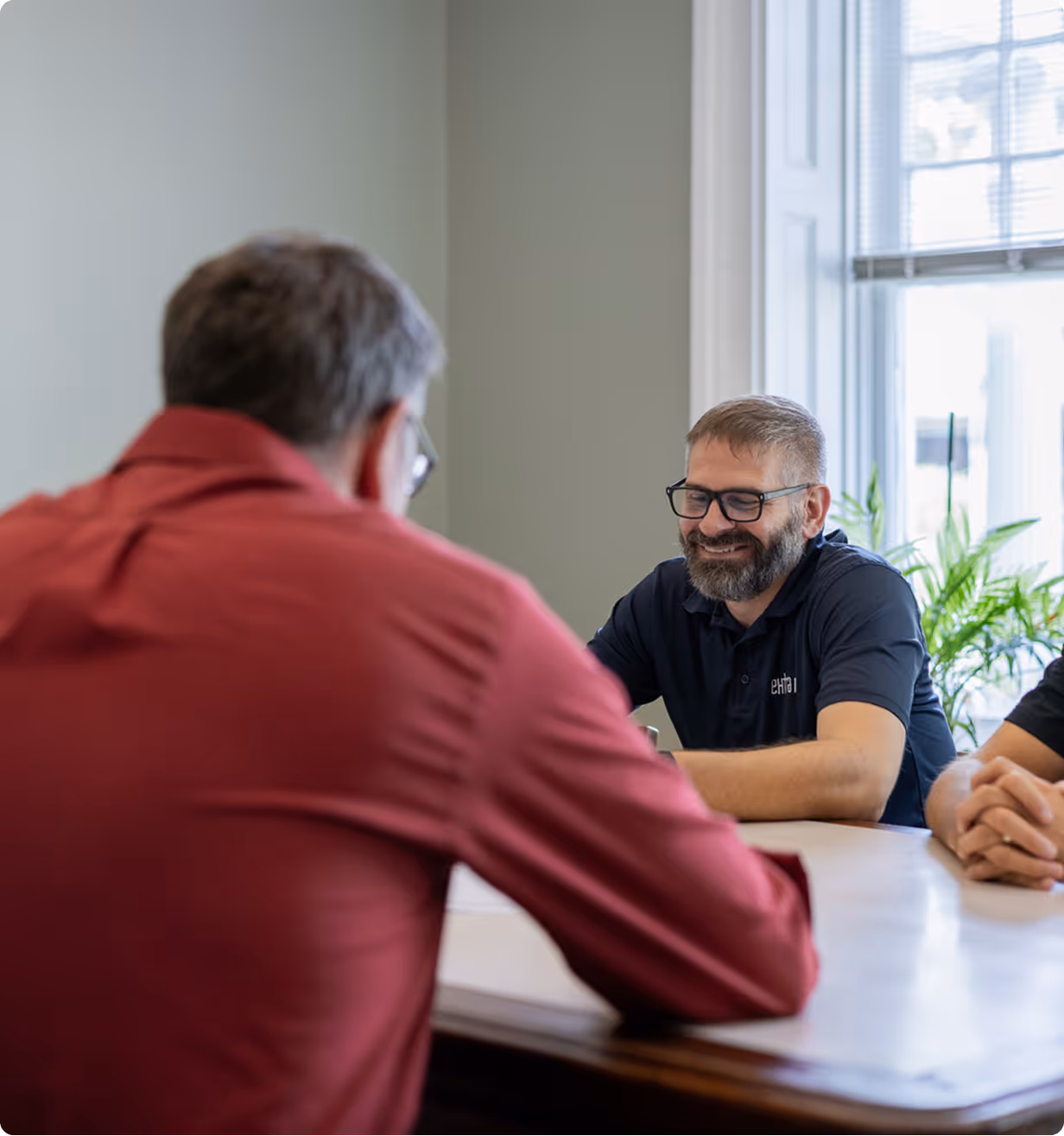 Owner Mike Davis in a consultation with an IT customer, smiling while talking about Managed IT plans