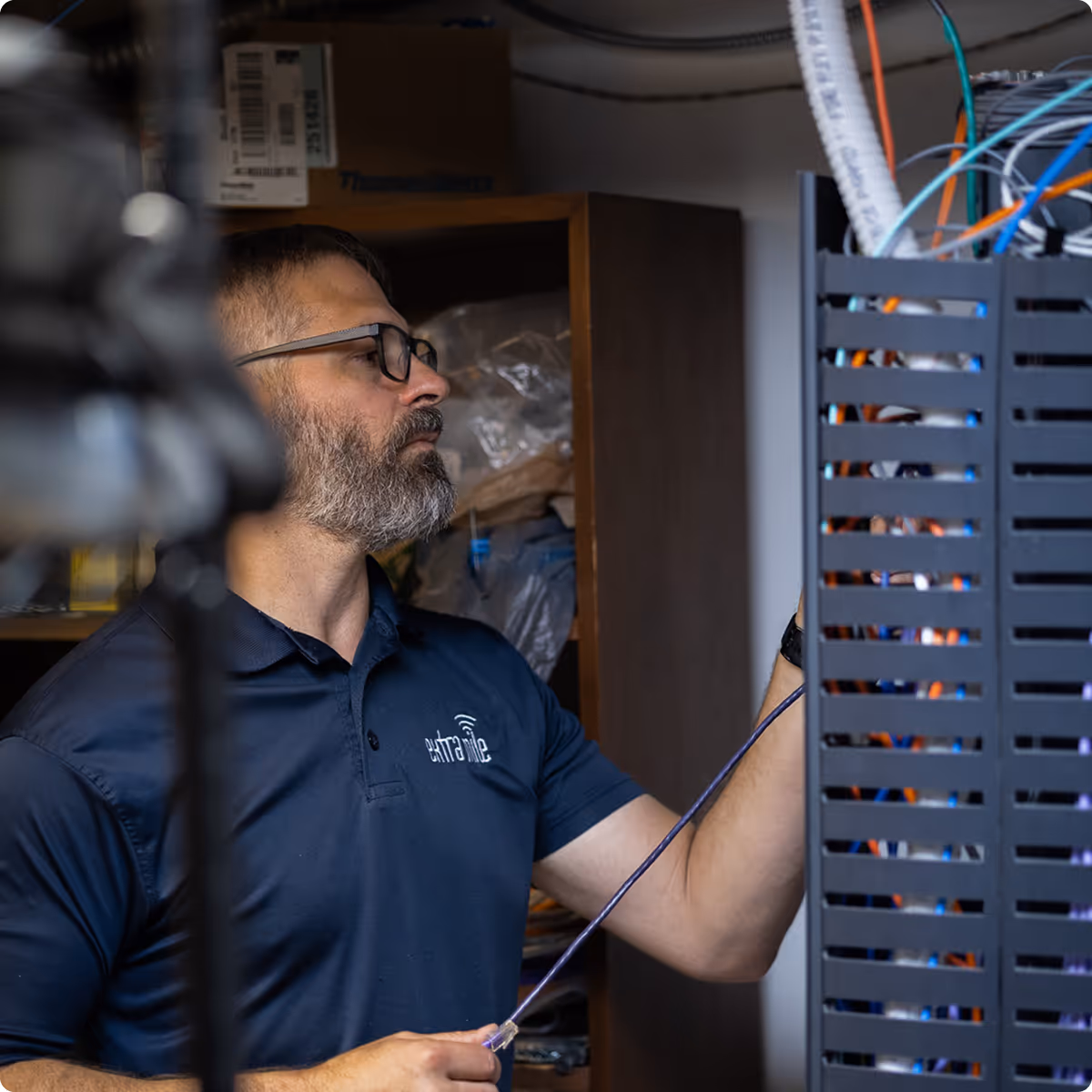 Owner Mike Davis working on a server rack and plugging in cables