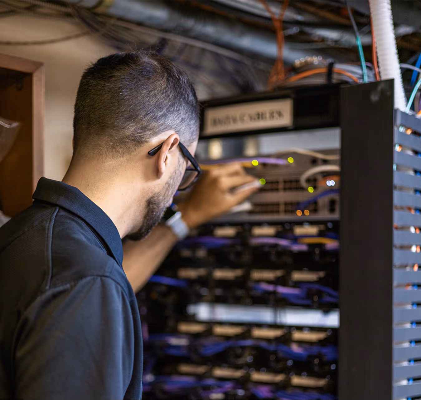 Extra Mile technician Tom installing cables on a server rack