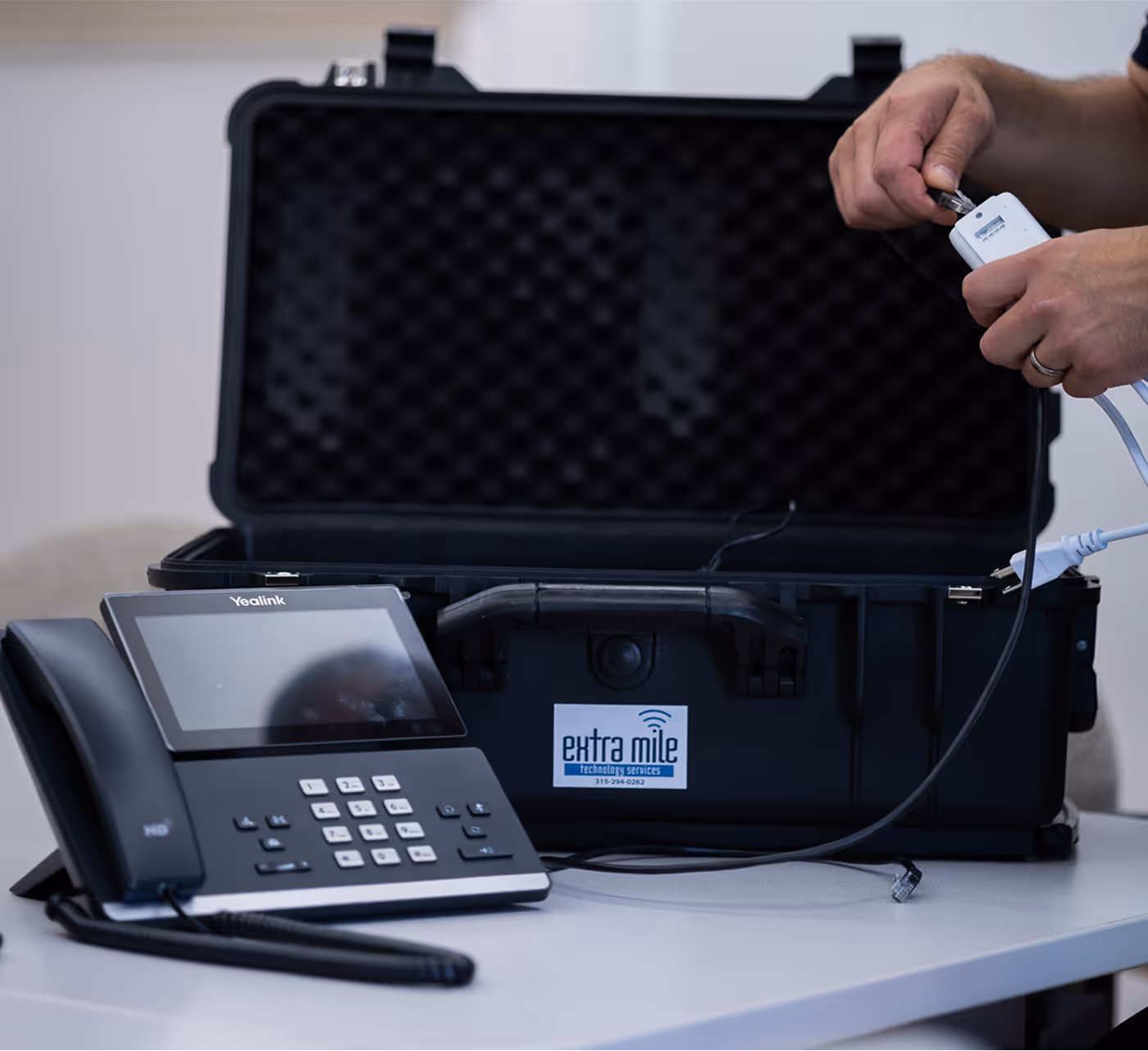 A VoIP business phone being set up and plugged into cables