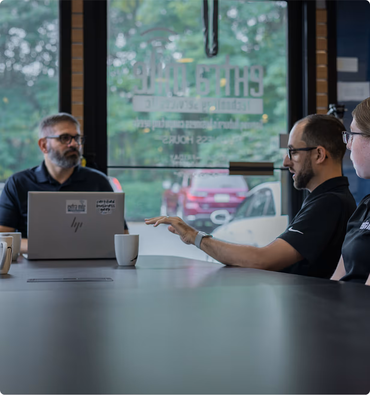 The Extra Mile team meeting at a conference table in their office to discuss IT projects