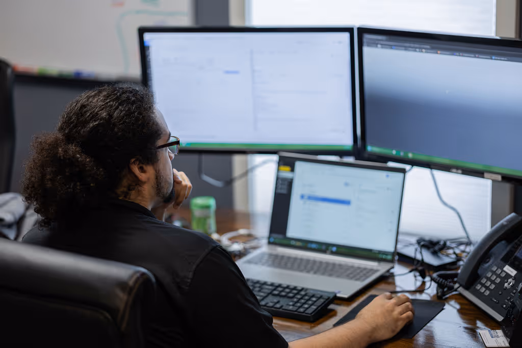 Extra Mile technician, MJ, sitting at his desk and working on a task