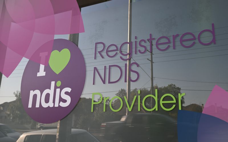 Registered NDIS provider signage on glass door.