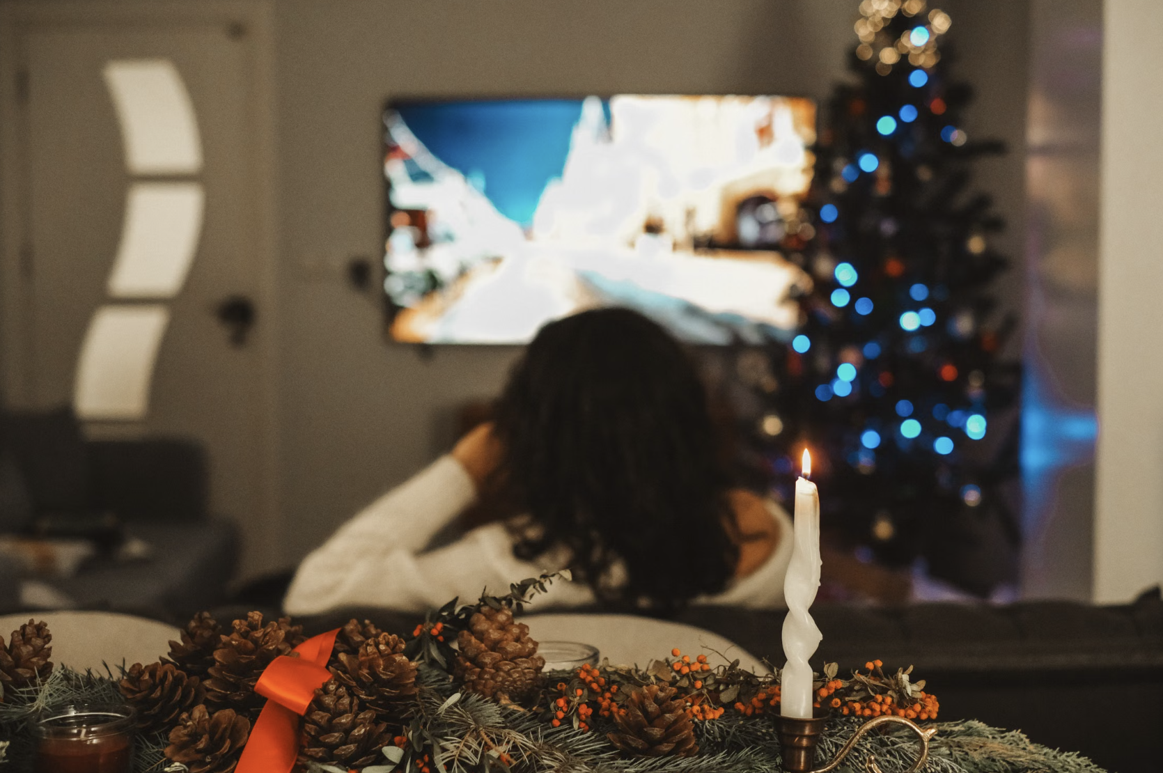 Woman watching TV during winter holidays