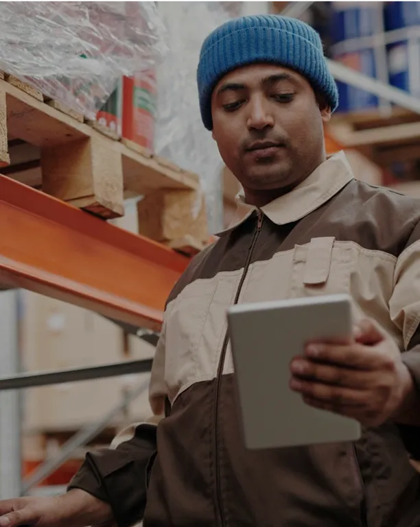a man holding a tablet with warehouse data