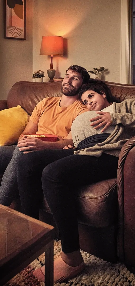 A man and a woman sitting on a couch.