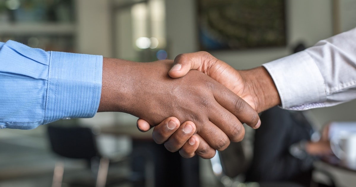 A founder and coach in a focused one-on-one conversation in a bright modern office