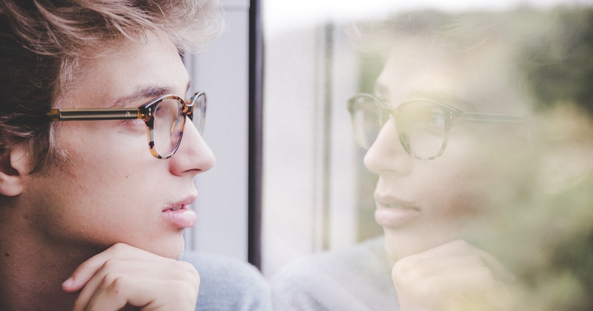 A founder sits alone at a window weighing a hard call, the kind of inner-game moment no operating playbook solves.