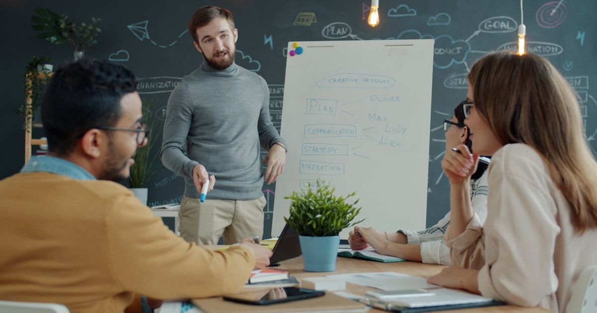 A founding team works through priorities at a whiteboard during a working session.