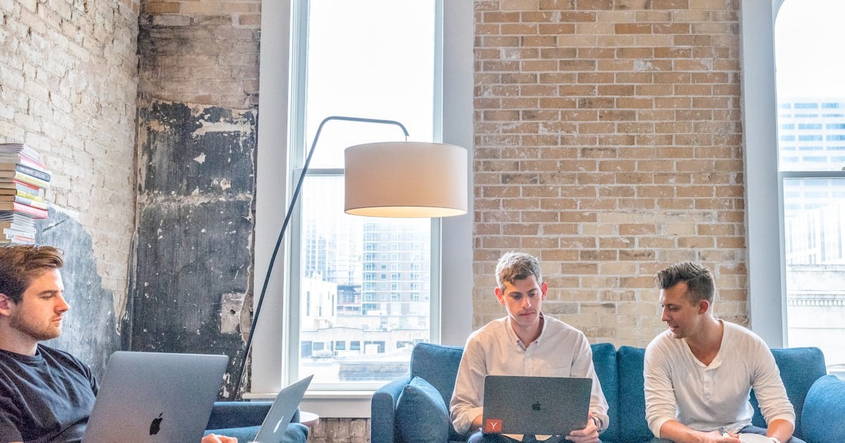 Startup founders strategizing together at a co-working table, an editorial leadership-development working session.