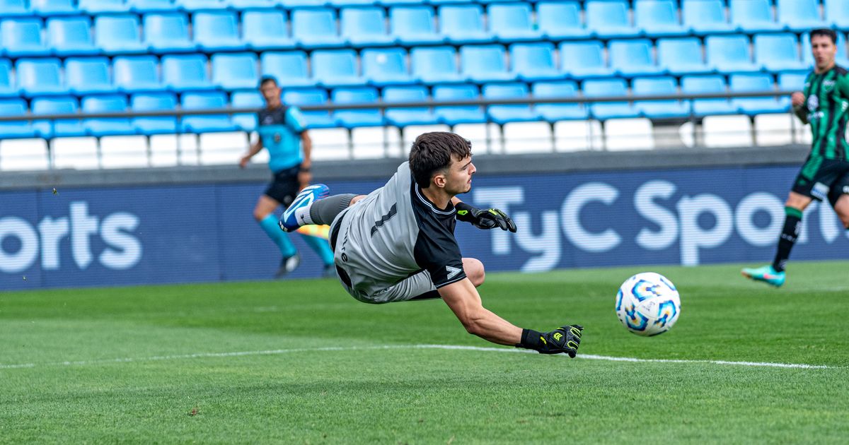 A soccer goalkeeper diving full stretch to one side of the goal during a match.