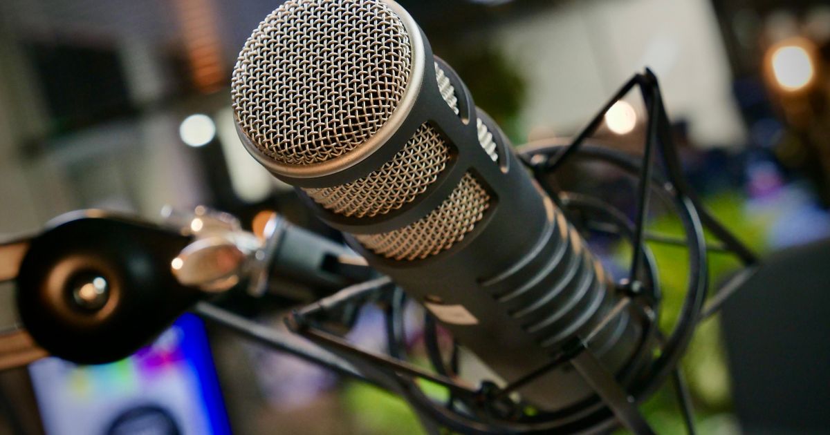 A studio microphone set up on a desk for podcast recording.