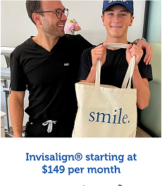 Two smiling men, one holding a beige tote bag with the word 'smile.' printed on it.