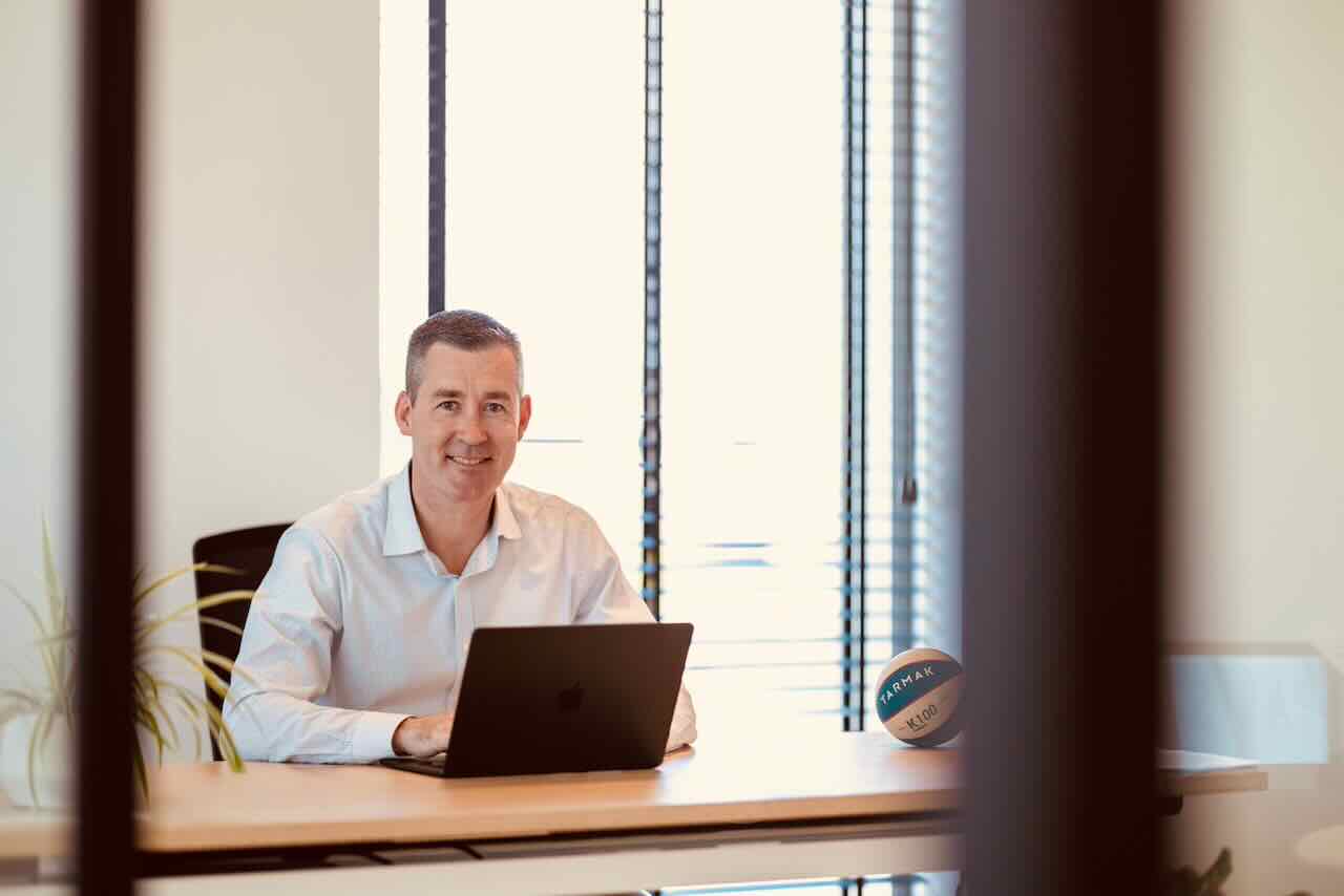 Tim achter zijn bureau