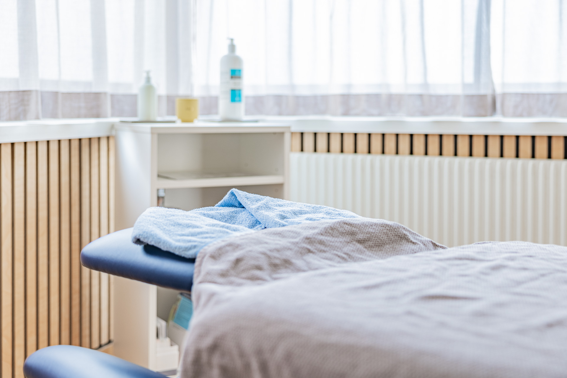 Detailansicht einer vorbereiteten Massageliege mit weichen Handtüchern in der Massage-Praxis Hoch-Gefühl in Diepoldsau. Fokus auf Entspannung und Wohlbefinden.