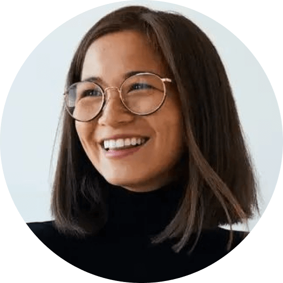 A woman with glasses smiling for a picture.