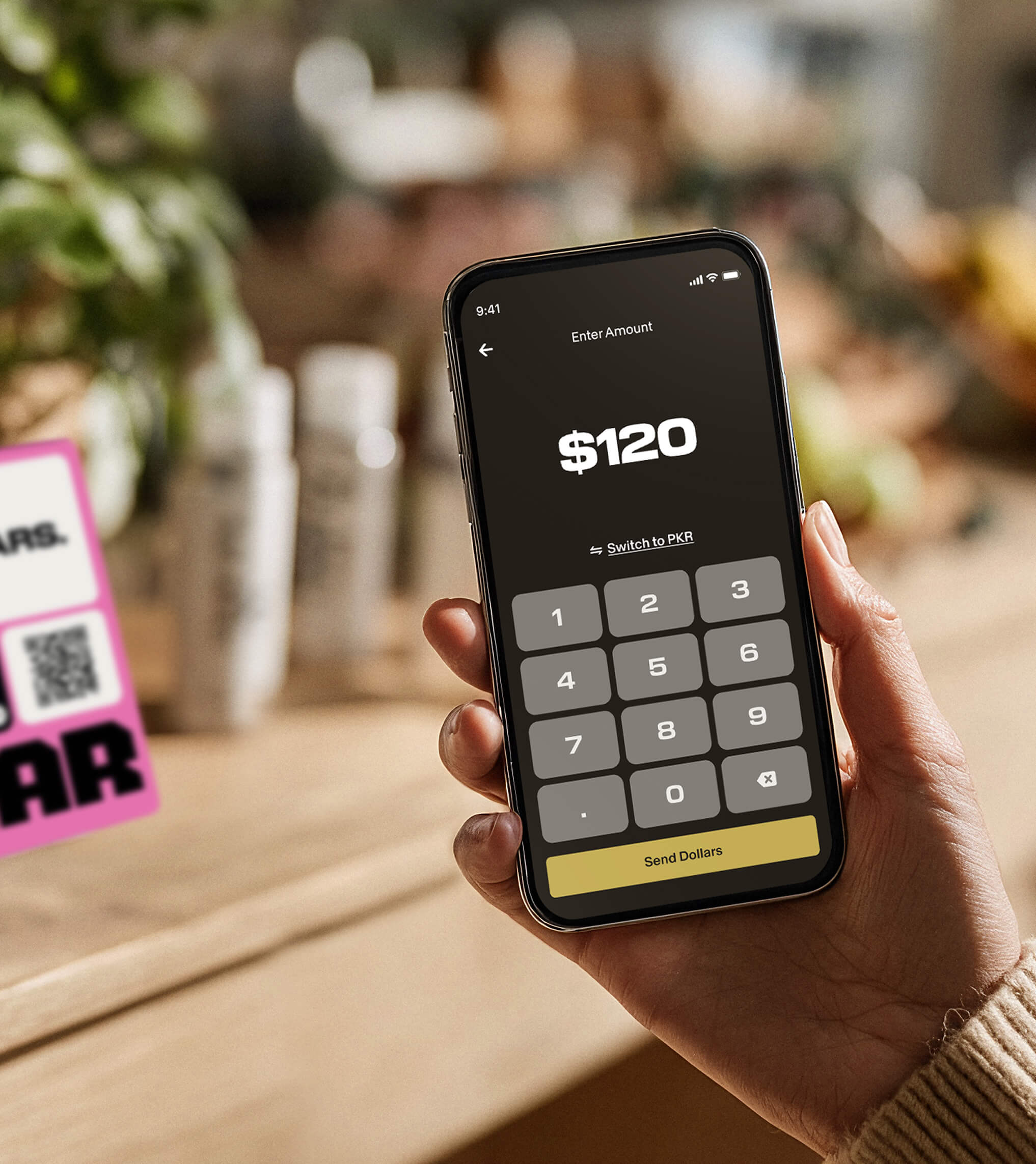 phone using the Zar app next to a sign advertising the Zar app