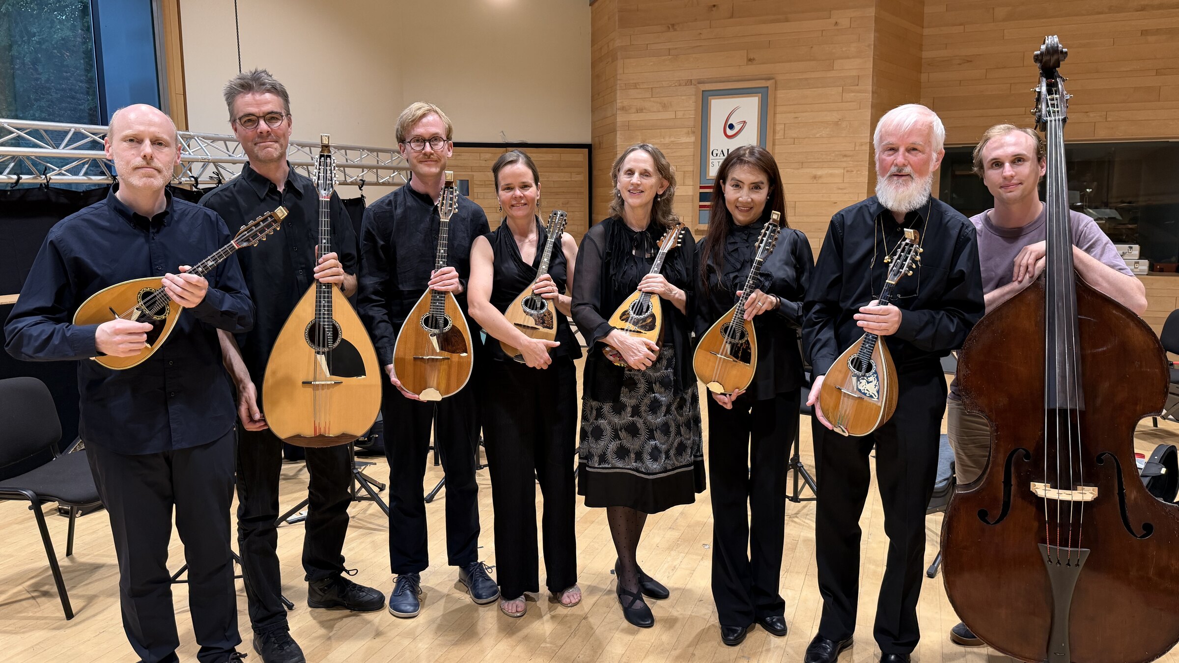 De acht muzikanten van mandoline-ensemble La Napolitaine met hun instrumenten en contrabas in de Galaxy Hall
