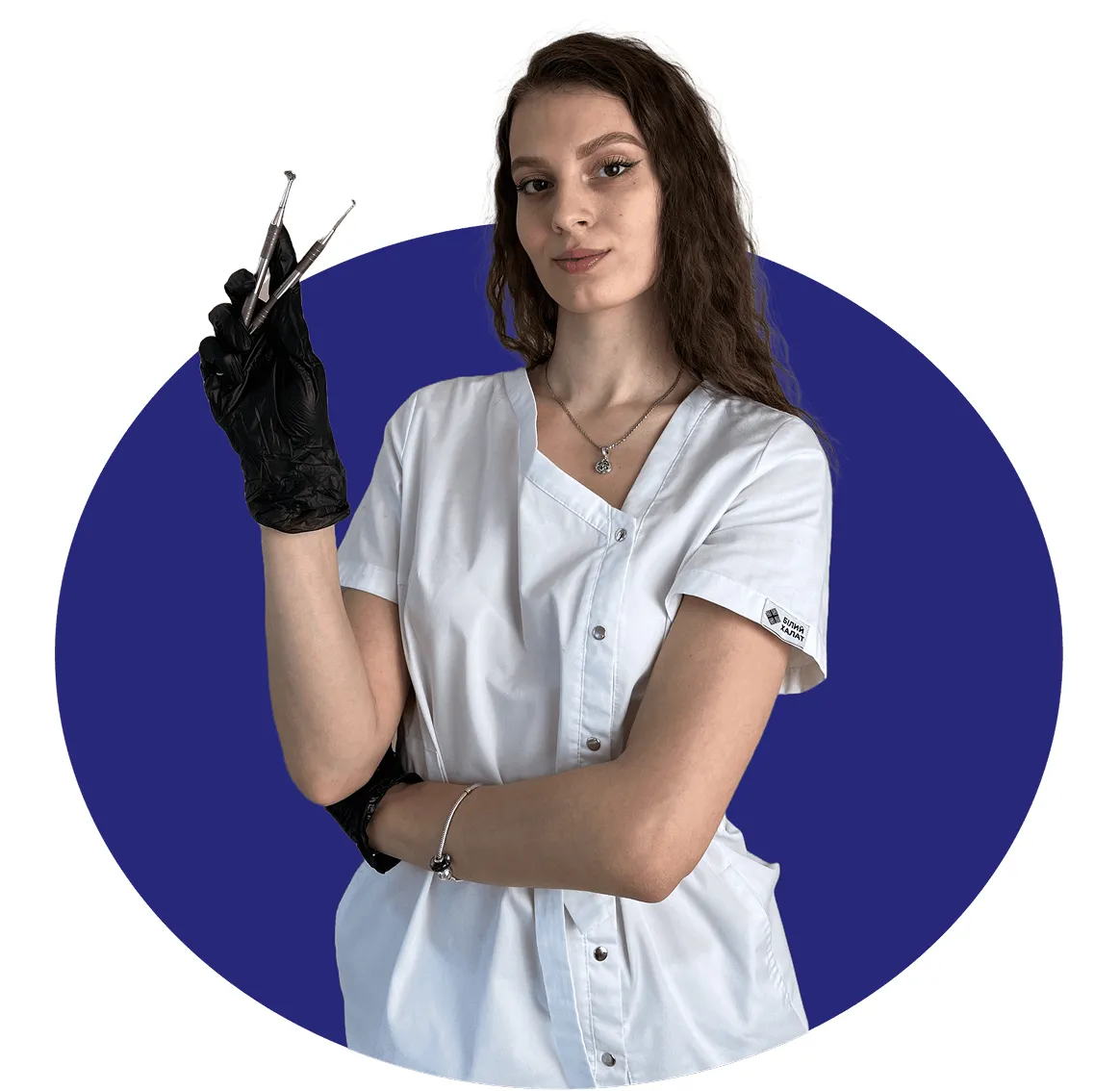 Female dental professional wearing white scrubs and black gloves holding dental tools against a blue circular background.