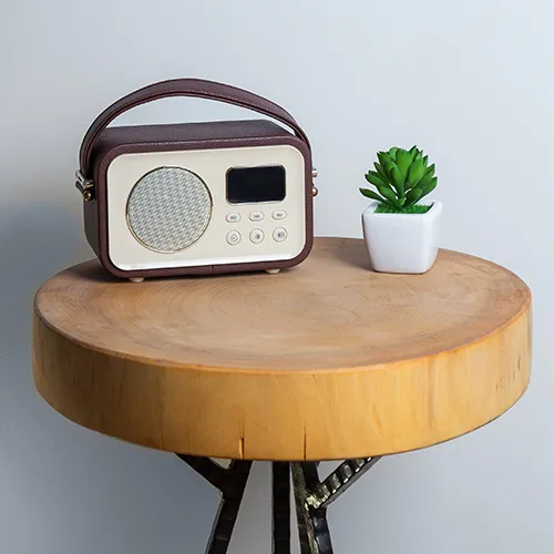 Tragbares Radio auf einem runden Holztisch.