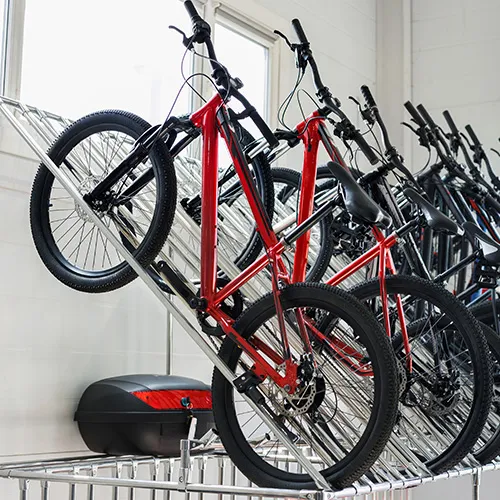 Fahrräder an vertikalem Fahrradständer im Innenraum.
