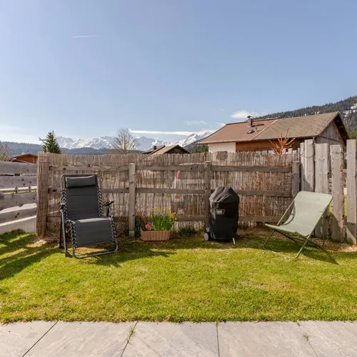 Zwei Liegestühle im Garten mit Bergblick.