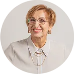 Lächelnde Frau mit Brille und goldenen Ketten.