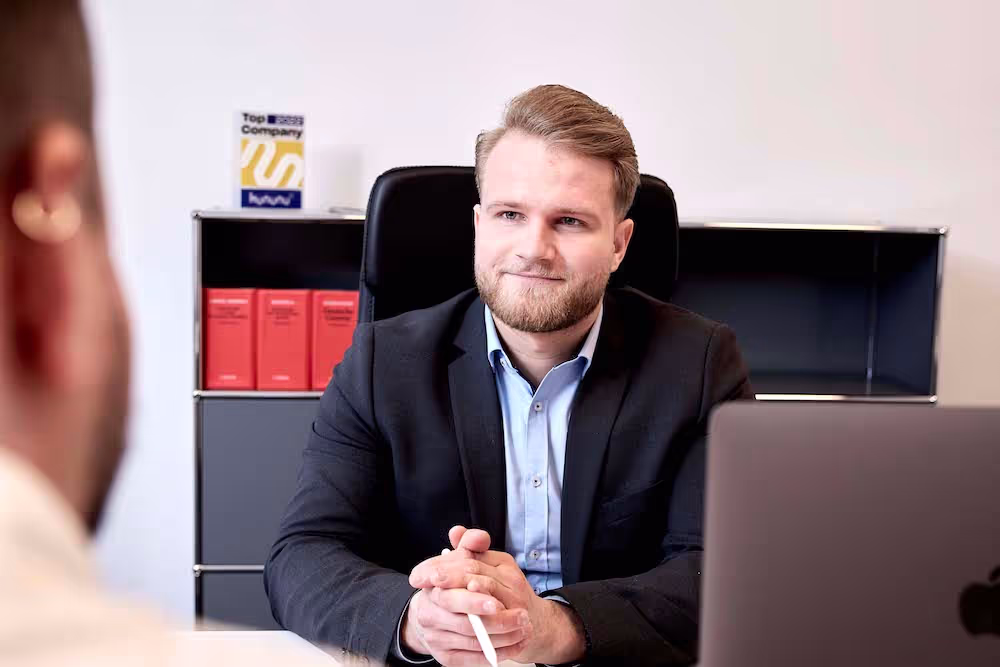 Business-Gespräch in einem modernen Büro: Ein professionell gekleideter Mann führt ein Bewerbungsgespräch mit einem Bewerber bei PG Digital.