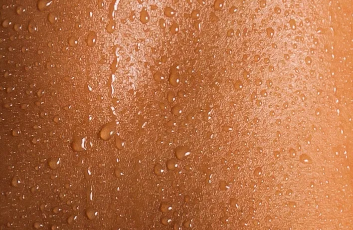 Close-up of healthy skin with water droplets, representing hydration and radiance.