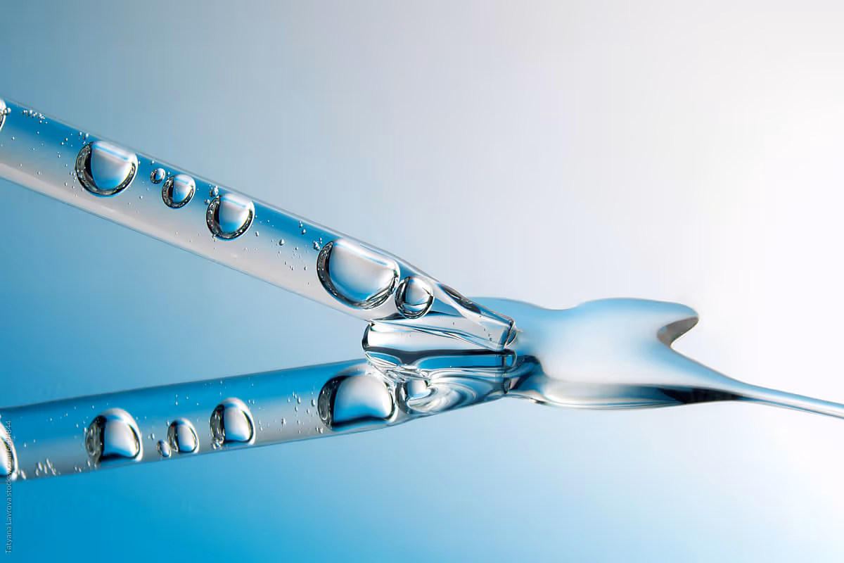 Exowell Exome suspension glass dropper bottle reflected on the surface of a glass.