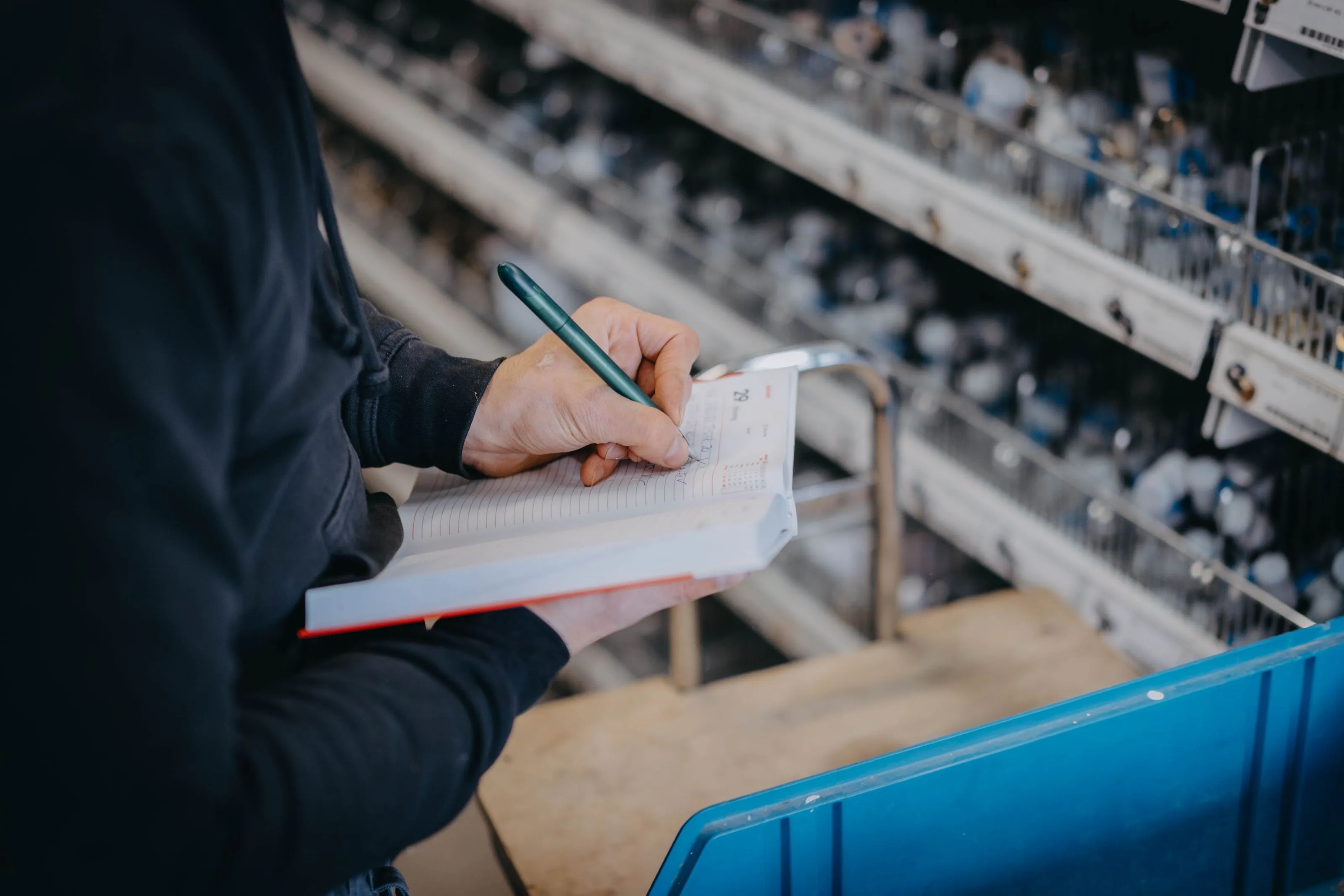 Person notiert Informationen in ein Notizbuch.