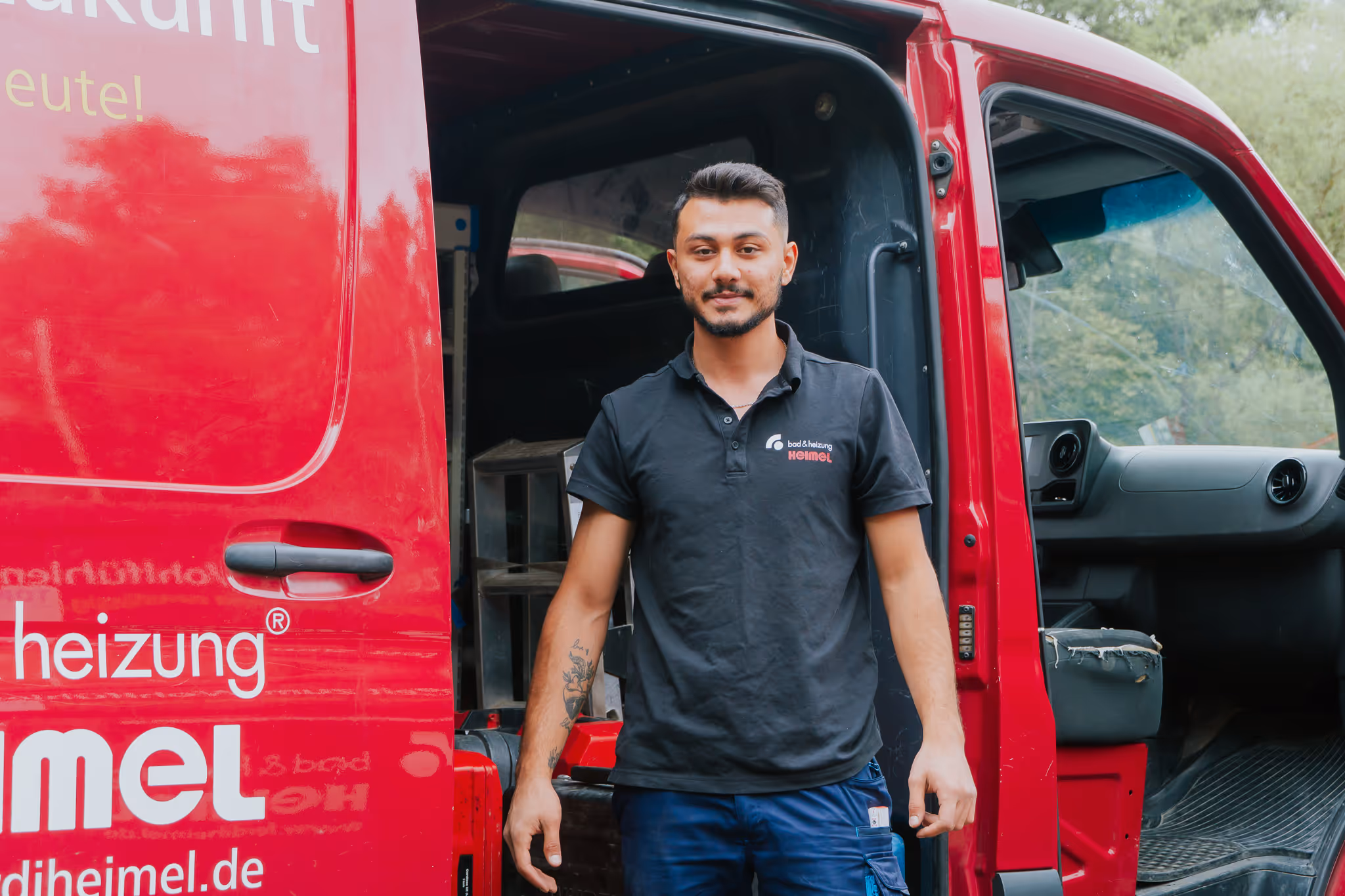 Heimel Mitarbeiter vor geöffnetem Firmenwagen