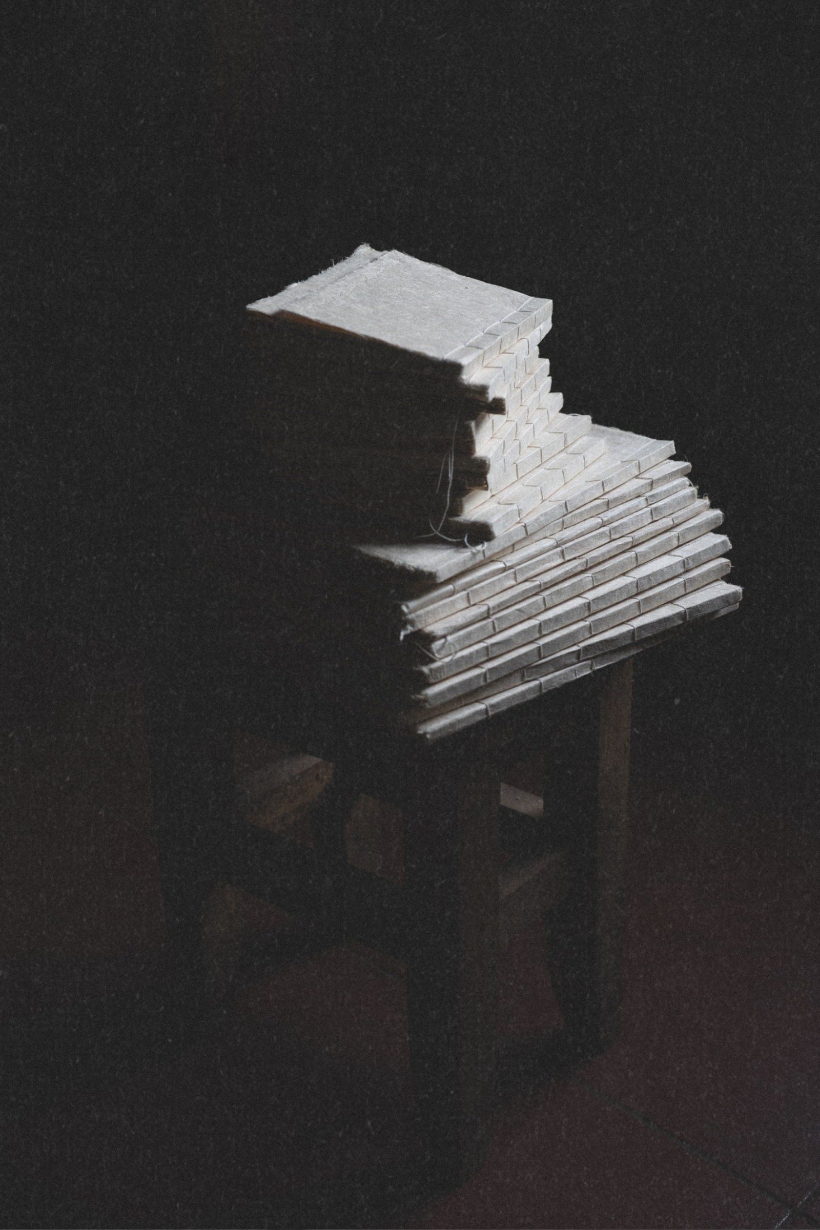 Stack of small handmade journals with varied natural paper textures in old world setting with fine art paper texture overlay.