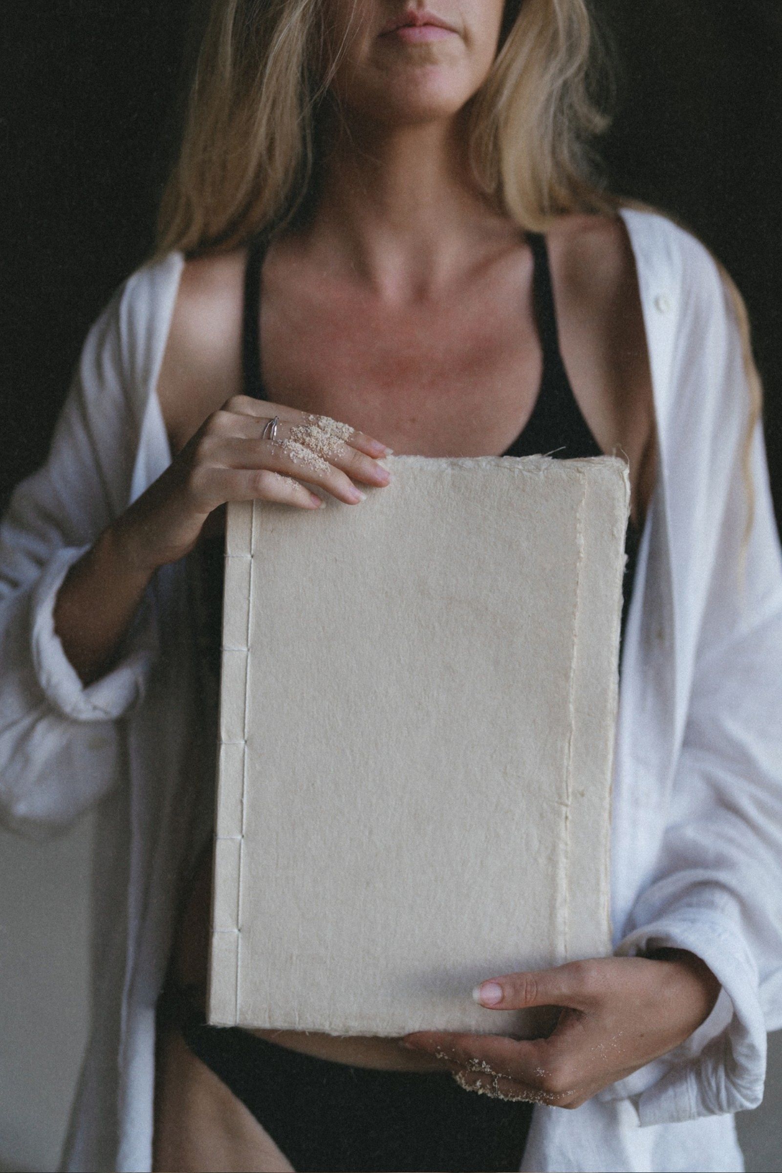 Woman on the beach holding a handcrafted journal made from traditional Vietnamese paper