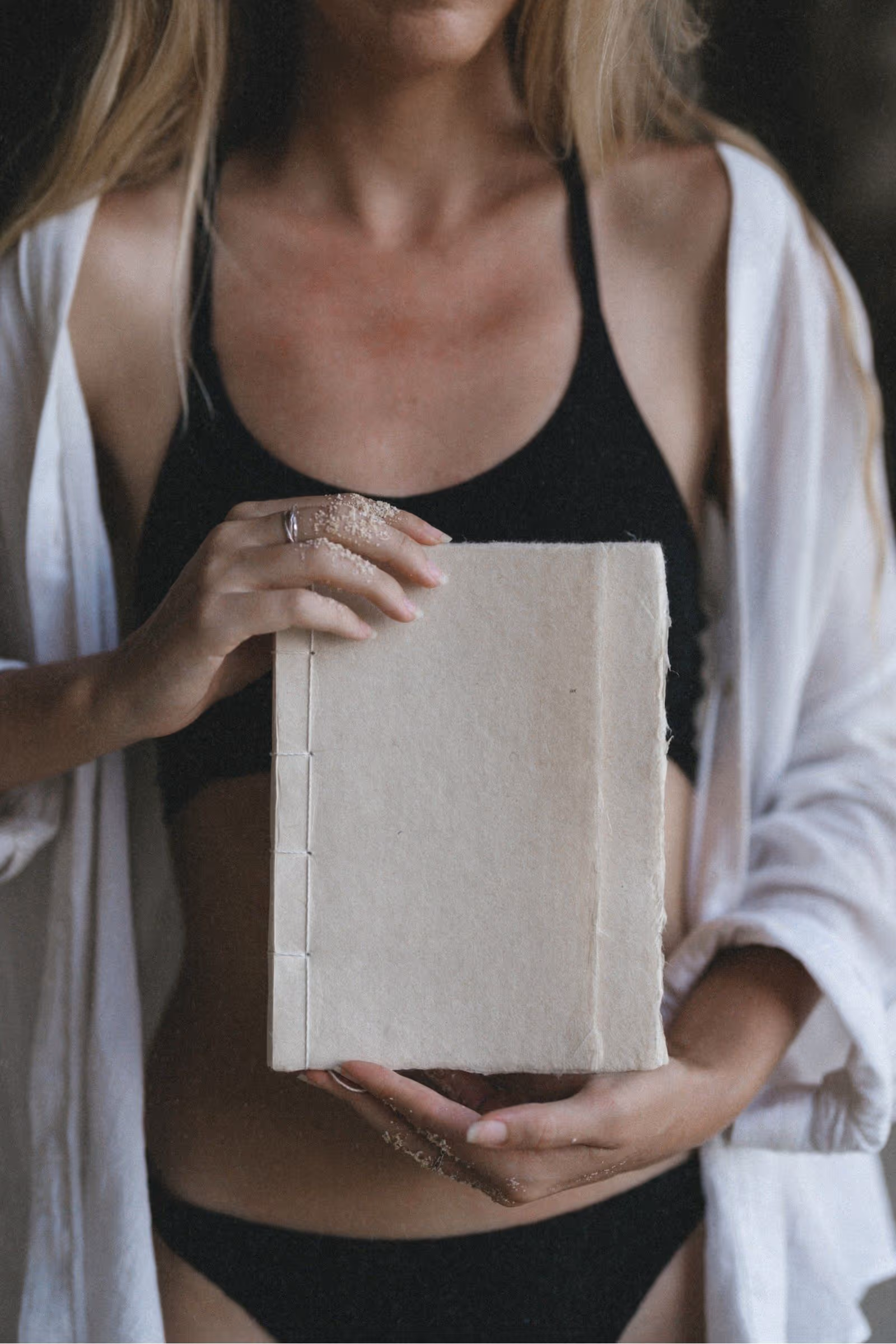 Woman on the beach holding a handcrafted journal made from traditional Vietnamese paper