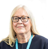 Headshot of a woman with long light hair, glasses and a navy top on a white background