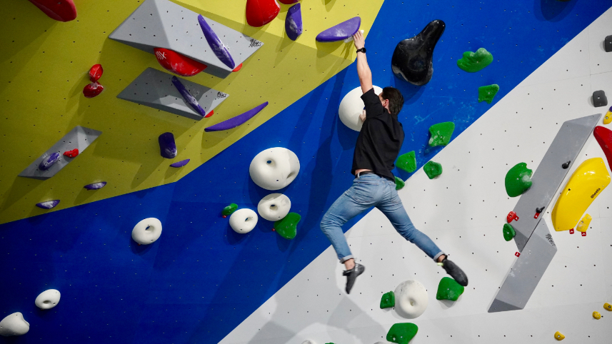 Climber moving through a steep blue and yellow section