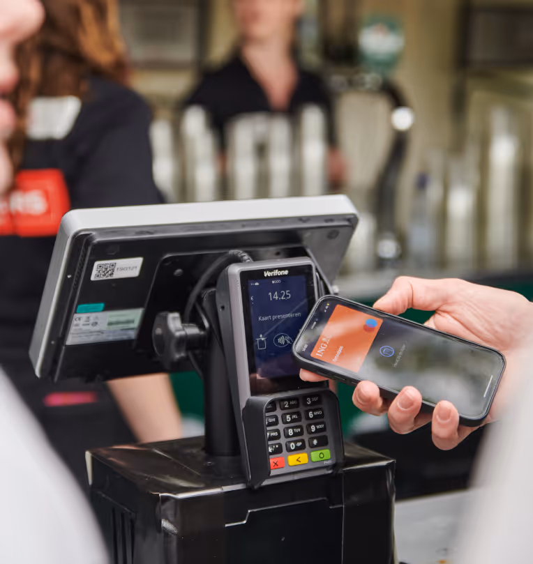 A close-up of a person using a smartphone to make a contactless payment