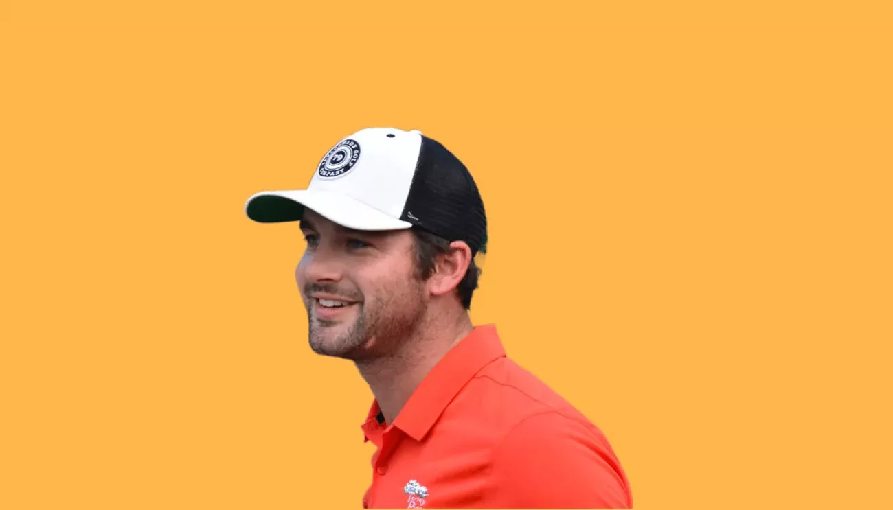 Erik standing in front of an orange background.