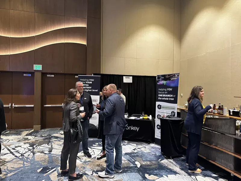 People socializing near the High Monkey booth at Accelerate 25 convention.