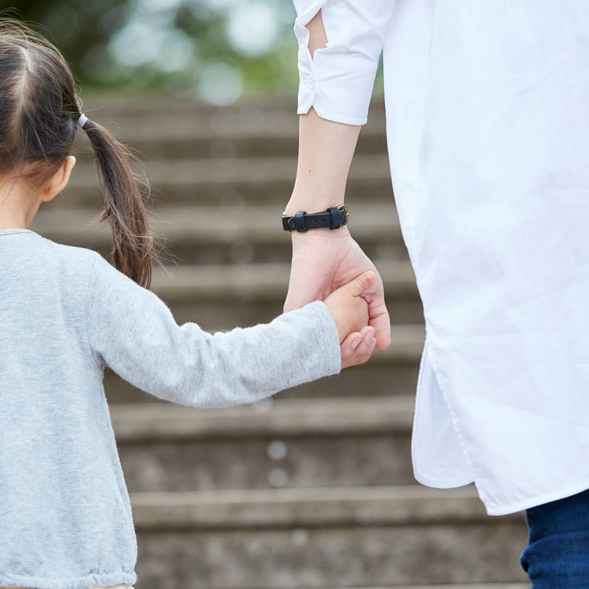 Child and adult holding hands