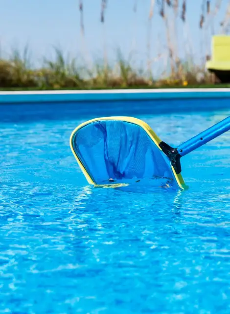 Mantenimiento de piscina con recogehojas azul durante limpieza profesional en Cambrils