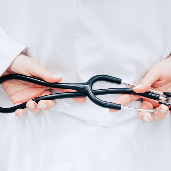 Hands of a doctor holding a stethoscope during a patient assessment