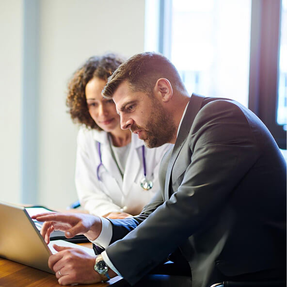 Clinical professionals reviewing study data together on a tablet in a healthcare setting.