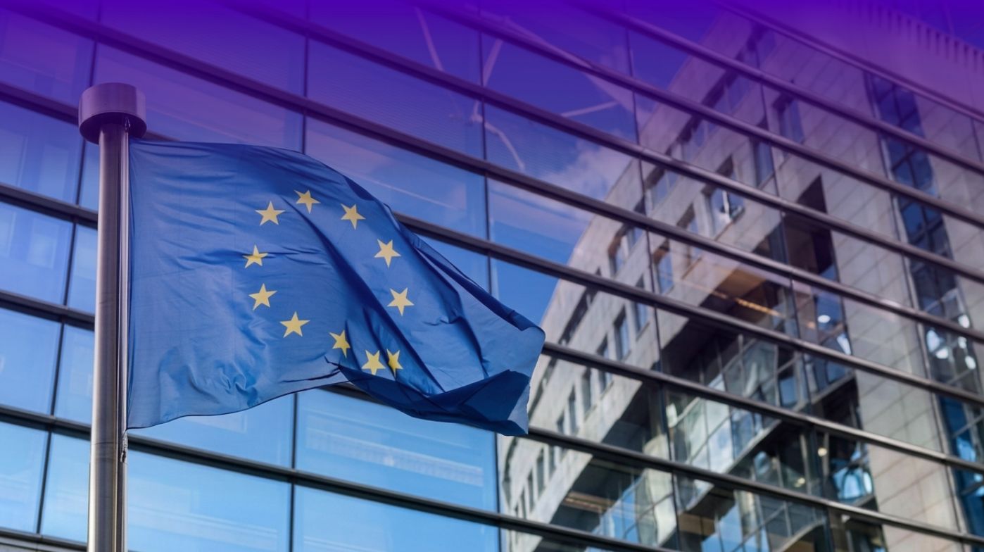 Bandiera dell'Unione europea che sventola davanti alla facciata in vetro di un edificio istituzionale europeo